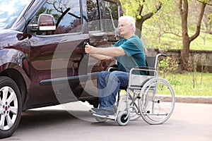 Man in wheelchair opening door of his van