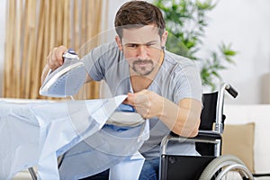 man on wheelchair preparing iron board