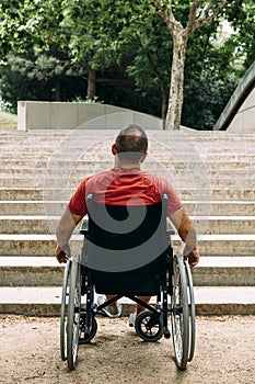 Man in wheelchair stopped in front of stairs