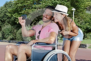 man in wheelchair taking selfie with girlfriend