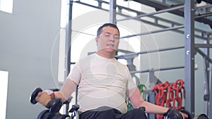 Man in a wheelchair trying to overcome muscles weakness.