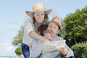 Man in wheelchair with wife looking at map