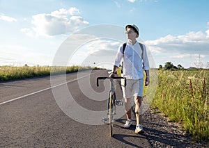 Man Wheeling Bicycle Along Rural Field