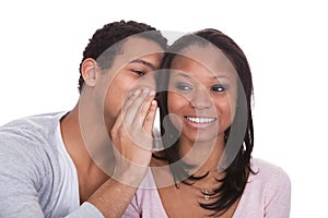 Man whispering to girlfriend's ear