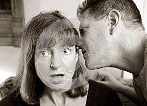 Man whispering to woman