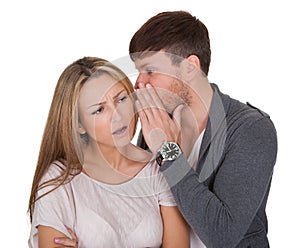 Man whispering in a woman's ear