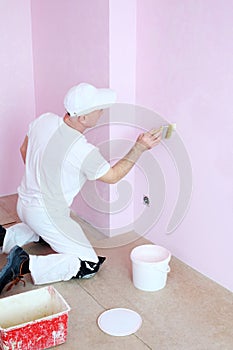 Man in white clothes covers the walls pink