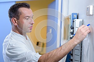 Man in white coat at clocking in machine