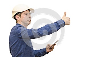 A man in a white construction helmet on a white isolated background looks into the phone and shows his thumb. Brigadier. Builder.