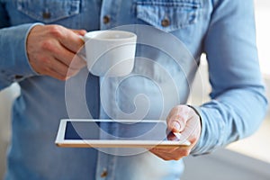 Man with white digital tablet and cup of coffee