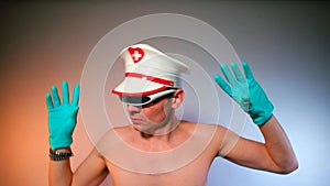 A man in a white hat and gloves makes dance moves at a nightclub party.