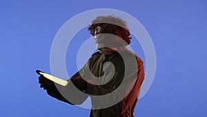 Man in white mask with sharp big knife in hands on blue background with red neon light. Image of maniac Jason Voorhees