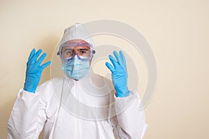 Man in white protective suit and goggles and surgical gloves to avoid getting coronavirus copy space