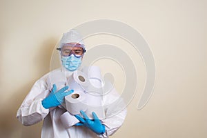 Man in white protective suit and goggles and surgical gloves with toilet paper in his hands to avoid getting coronavirus copy