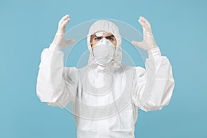 Man in white protective suit respirator mask isolated on blue background studio. Epidemic pandemic new rapidly spreading