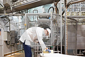 Man in a white robe and a cap make an inspection of the production line