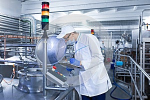 Man in a white robe and mask makes notes standing in the shop