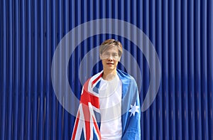 The man in white shirt with Australia flag on his shoulder on nature view background