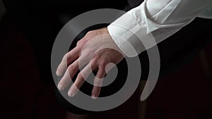 Man in white shirt hand on his knee in black pants suit. Businessman or manager in office sit waiting