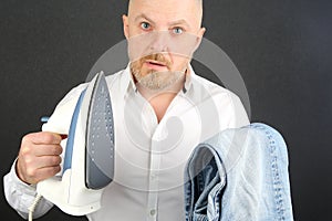 Man in a white shirt with an Ironing Flatiron and jeans in his hands