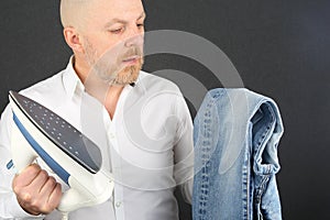 Man in a white shirt with an Ironing Flatiron and jeans in his hands