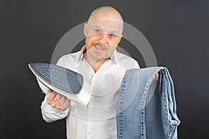 Man in a white shirt with an Ironing Flatiron and jeans in his hands