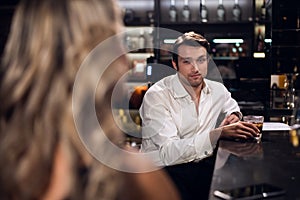 A man in a white shirt meets a young girl in a nightclub and flirts with her