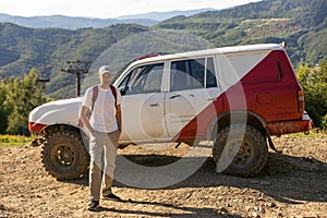 man white suv car at hill with beautiful mountains view. road trip.