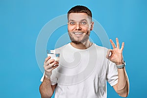 man in white t-shirt with drinking glass of water showing Ok gesture