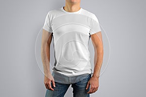 Man in a white t-shirt is isolated on a gray background.
