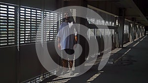 Man in a white T-shirt standing in the parking lot near the grate