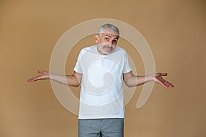 A man in a white tsirt looking uncertain and confused