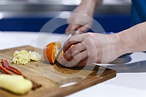 Man who cuts citrus on a wooden hoe