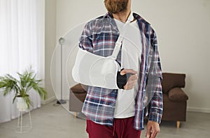 Man who has broken arm, hand, wrist or elbow is wearing bandage and support sling