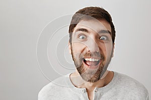 Man who lost weight looks with crazy eyes at sweets. Studio shot of funny weird guy with beard and strange smile