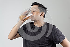 a man who is sweating after work feels very thirsty and drinks quickly to the point of ignoring the straw of his drink