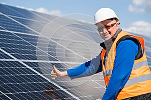 Man who works with electric solar panels shows a thumbs up.