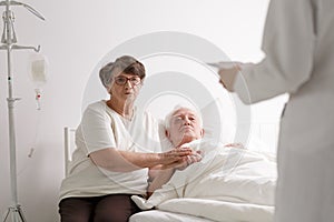 Man with wife listening diagnosis