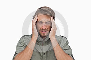 Man wincing with pain of headache photo