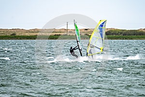 Man windsurfing close to the town of Caernarfon in Wales - United Kingdom