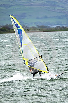 Man windsurfing close to the town of Caernarfon in Wales - United Kingdom