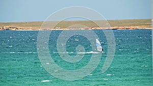 Man Windsurfing in the water during a sunny summer day. Shot. Beautiful view of the sea and windsurfer on a Sunny day