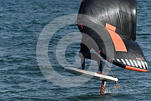 A man is wing foiling using handheld inflatable wings and hydrofoil surfboards