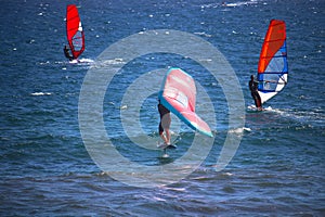 Man wing foiling among windsurfers at the Atlantic ocean