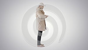 Man in winter clothes using sanitizer spray to prevent flu disease on gradient background.