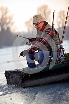 Man on winter fishing on the frozen lake