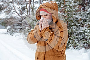 Man in a winter forest looking sick and unwell