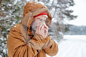 Man in a winter forest looking sick and unwell