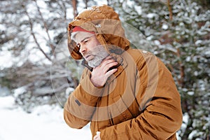 Man in a winter forest looking sick and unwell