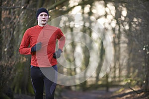 Man On Winter Run Through Woodland